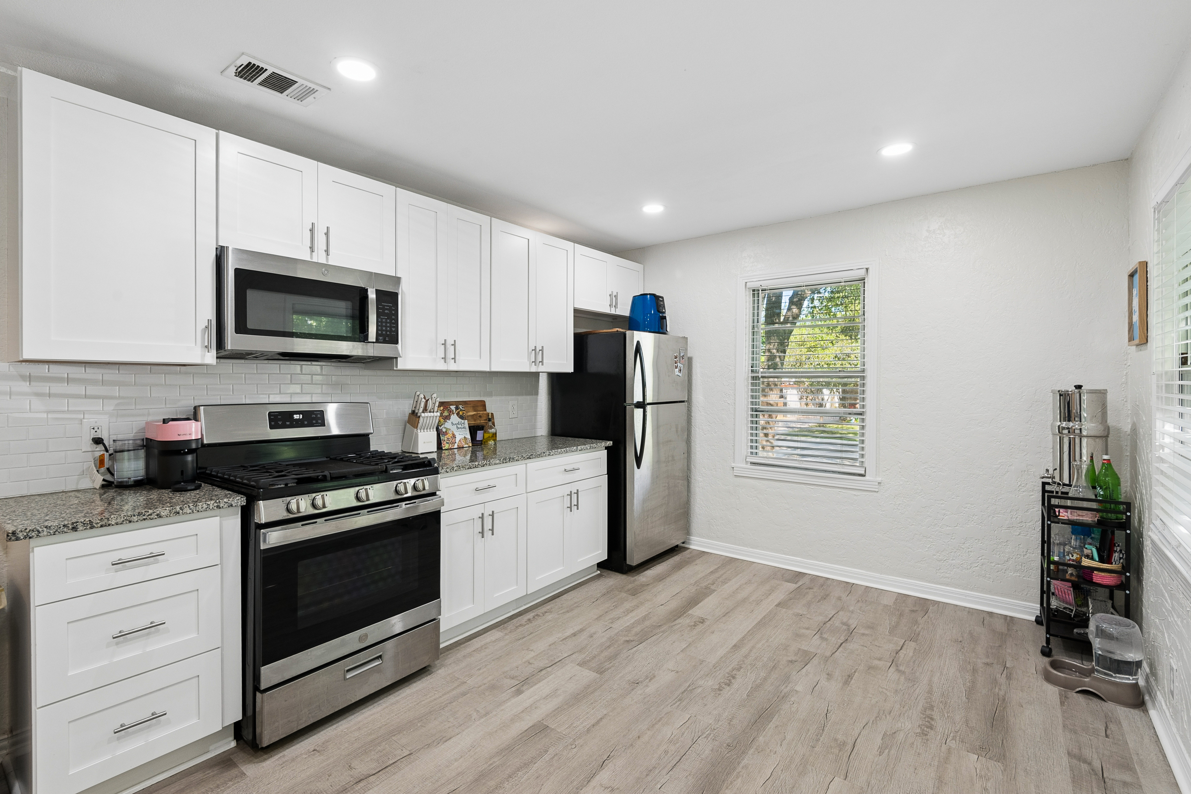 Kitchen with white cabinets and hardwood floors at 2821 S Hills Ave