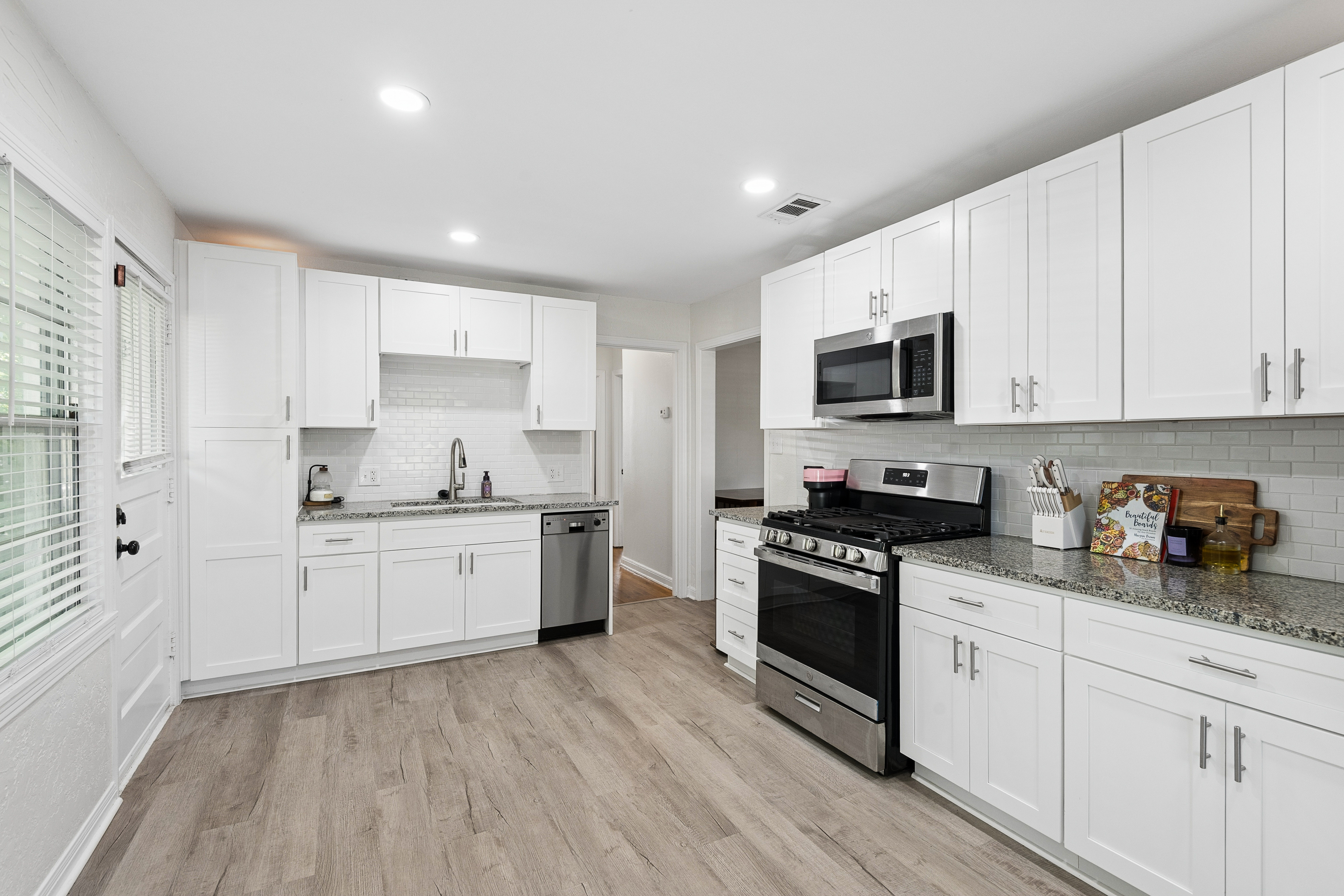 Kitchen with white cabinets and hardwood floors at 2821 S Hills Ave