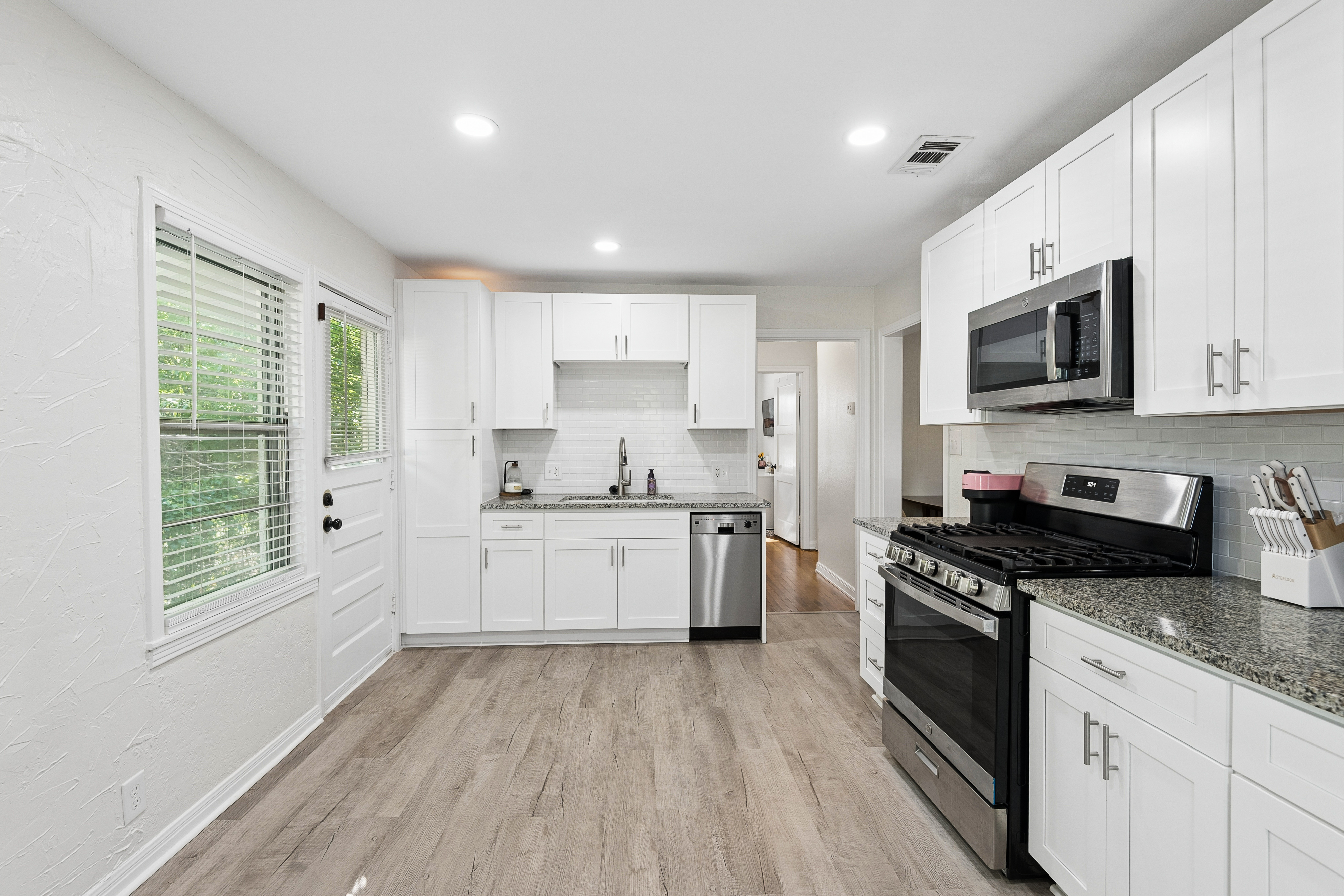 Kitchen with white cabinets and hardwood floors at 2821 S Hills Ave